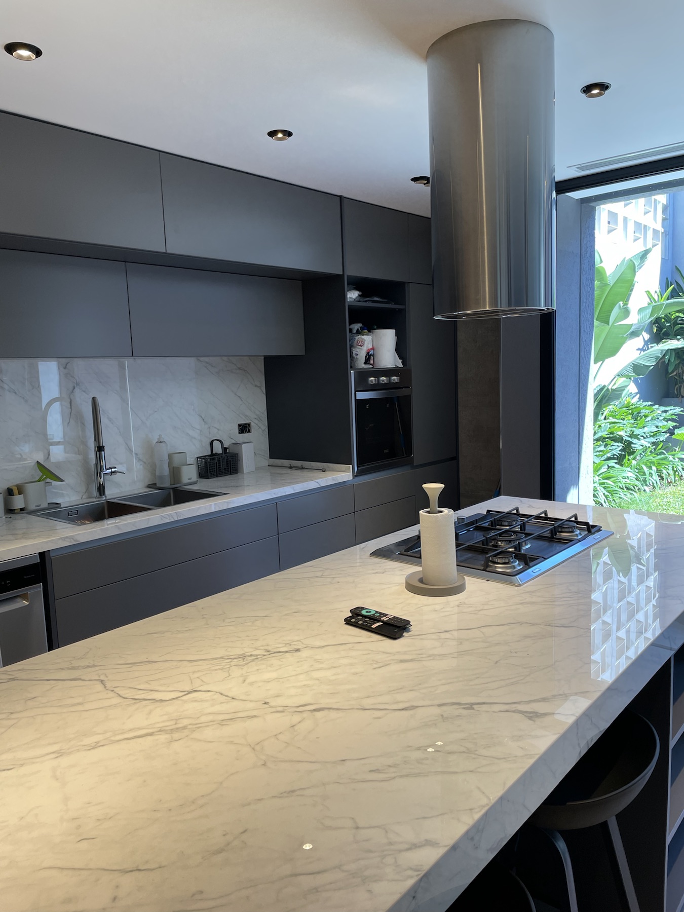 Cocina de mármol y mobiliario oscuro en el proyecto César Díaz